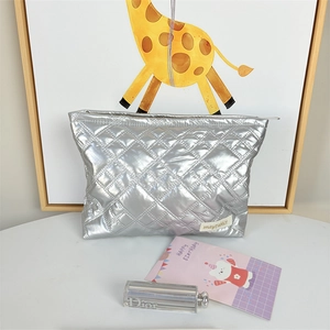 Detailed macro view of silver quilted PU leather makeup bag with diamond stitching