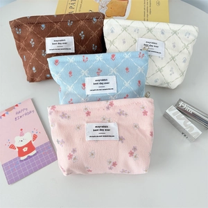 Vue détaillée de quatre trousses à maquillage en velours côtelé aux motifs de fleurs et nœuds