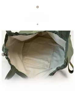 Detail view of large nylon tote bag featuring spacious cream lining and secure zipper pocket