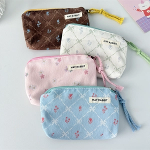 Detailed view of four colorful floral corduroy mini pouches with textured quilting and zippers