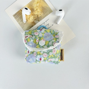 Detailed view of floral fabric earphone case with delicate lace trim and secure snap