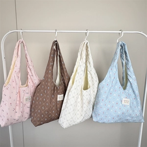 Detail showing four assorted floral and plaid printed tote bags in pastel colors