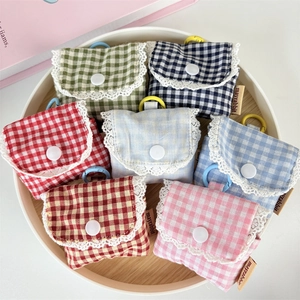 Close-up of seven colorful plaid earphone pouches with lace trim and snap closure