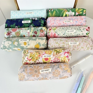 Primer plano de estuches de lona con flores en relieve y detalles de cremallera