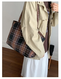 Detailed view of large checkered tote bag in coffee and black on model shoulder