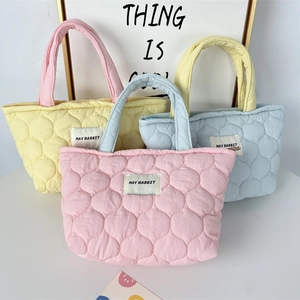 Three quilted puffer bags in pastel pink, yellow and blue with May Rabbit woven label