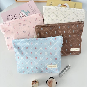 Detailed arrangement of corduroy floral makeup bags in pink, beige, and blue colors