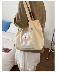 Detail of cute Lucky Puppy embroidery and pink scarf on beige canvas tote bag