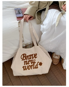 Detail of corduroy tote bag with Brave New World print and green checkered lining