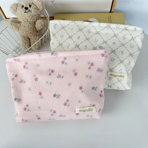 Detail of pink floral corduroy and quilted bow makeup bags with brand woven label