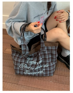 Close-up of vintage plaid tote bag with elegant white cursive embroidery on thick fabric