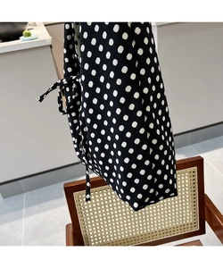 Close-up of black polka dot tote bag with stylish bow tie detail on the fabric side