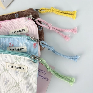 Flat lay of colorful corduroy floral coin purses in brown, pink, blue, and white colors