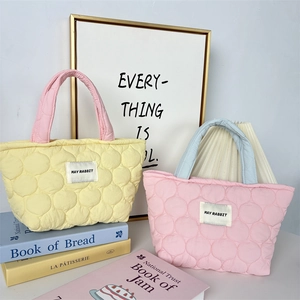 Close-up of quilted candy-colored tote bags with contrast handles and bubble texture
