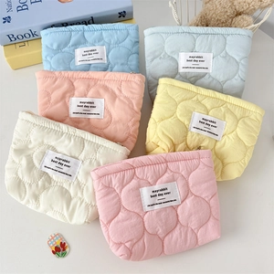 Detailed view of quilted heart pattern and soft fabric textures on colorful cosmetic bags