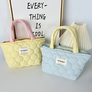 Detailed view of quilted handbag with May Rabbit label and smooth metal zipper closure