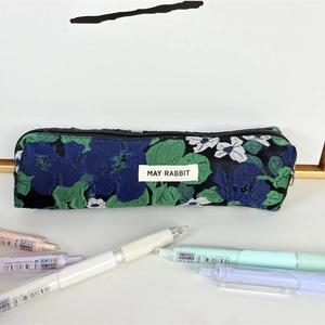 Detalle de estuche de jacquard floral con bordado vintage y cierre de cremallera metálica