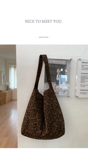 Detail of wool leopard print tote bag hung on wall with minimalist fashion magazines