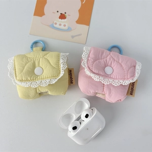 Macro view of quilted fabric earphone case with lace trim and round button detail