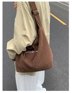 Outdoor shot of brown corduroy tote bag with Bonne journée embroidery on the shoulder