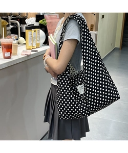Polka dot canvas tote bag shown worn over the shoulder in a lifestyle cafe setting