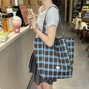Grand sac cabas en toile à carreaux bleus et marrons avec étiquette blanche élégante