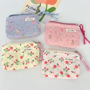Detail of four quilted mini makeup pouches with floral and cute animal prints and zippers