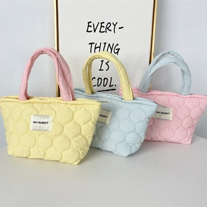 Detail view of colorful quilted handbags with macaron tones and May Rabbit woven label