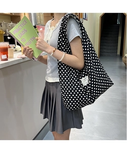 Detail view of large canvas tote bag with white polka dots on black fabric for women