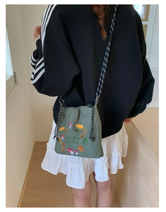 Close-up of army green nylon crossbody bag featuring delicate mushroom and leaf embroidery