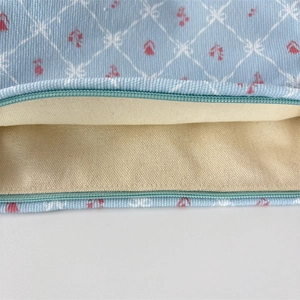 Detail view of light blue corduroy fabric with floral print and inner canvas lining