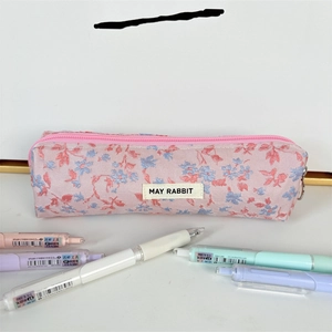 Primer plano del estuche floral con logotipo May Rabbit y cierre de cremallera suave