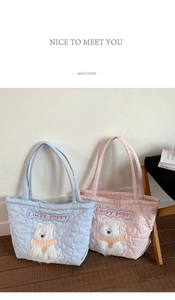 Detail of pink and blue quilted tote bags featuring cute Lucky Puppy plush embroidery