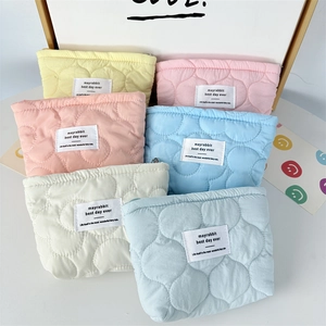 Close-up of quilted floral cosmetic bags in multiple pastel colors with wave stitching