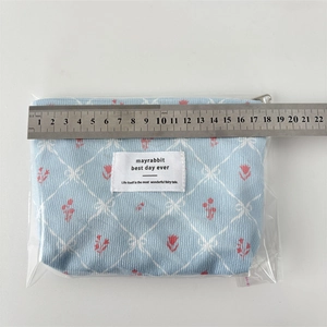 Détail des dimensions d'une trousse de toilette en velours bleu à fleurs avec règle