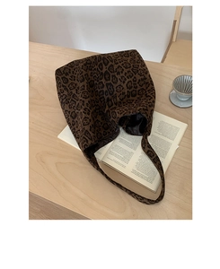 Close-up of leopard print wool tote bag on wooden table with aesthetic magazine