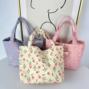Detailed view of quilted cotton lunch bags featuring floral, bear, and strawberry patterns