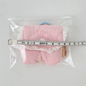 Detailed view of a pink quilted fabric earphone case measured at 8cm with white lace trim