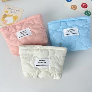 Quilted floral makeup bags in pink, blue, and white with elegant top zippers