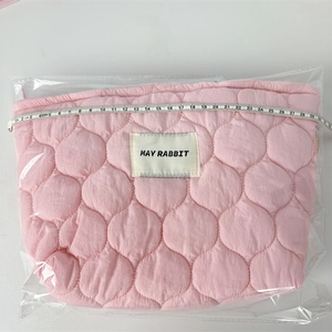 Pink quilted tote bag with soft wavy stitching and brand label, measuring 30cm wide