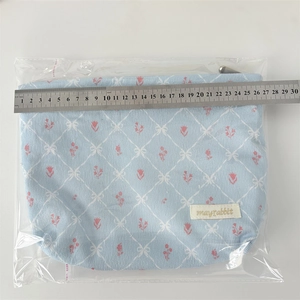 Detailed view of corduroy bow makeup bag measuring 26cm width with tulip pattern