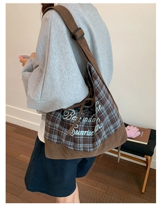 Close-up of brown corduroy and plaid patchwork tote bag with stylish letter printing