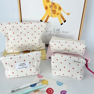 Macro view of canvas makeup bag featuring red heart patterns and durable zipper closure