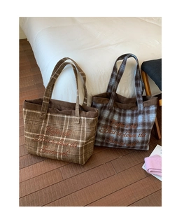 Close-up of checkered wool tote bags featuring embroidery and brown corduroy trim