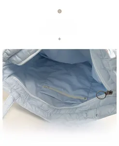 Detail view of the quilted tote bag interior featuring a blue lining and zipper pocket