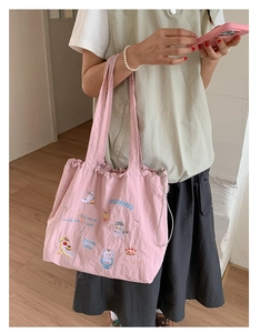 Close-up of pink tote bag featuring cute cat embroidery and drawstring detail