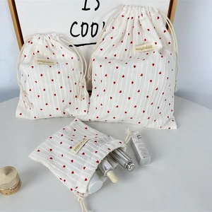 Set of three striped cotton drawstring storage bags with red heart patterns