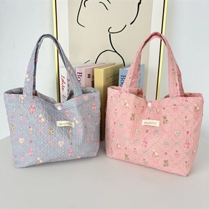 Close-up of quilted floral tote bags with cute animal prints and snap button closure