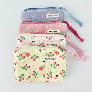 Detail showing set of four pastel floral canvas pouches with textured fabric and woven puller