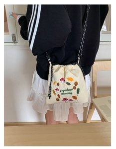 Detail of cute nylon crossbody bag with cartoon embroidery and woven drawstring strap